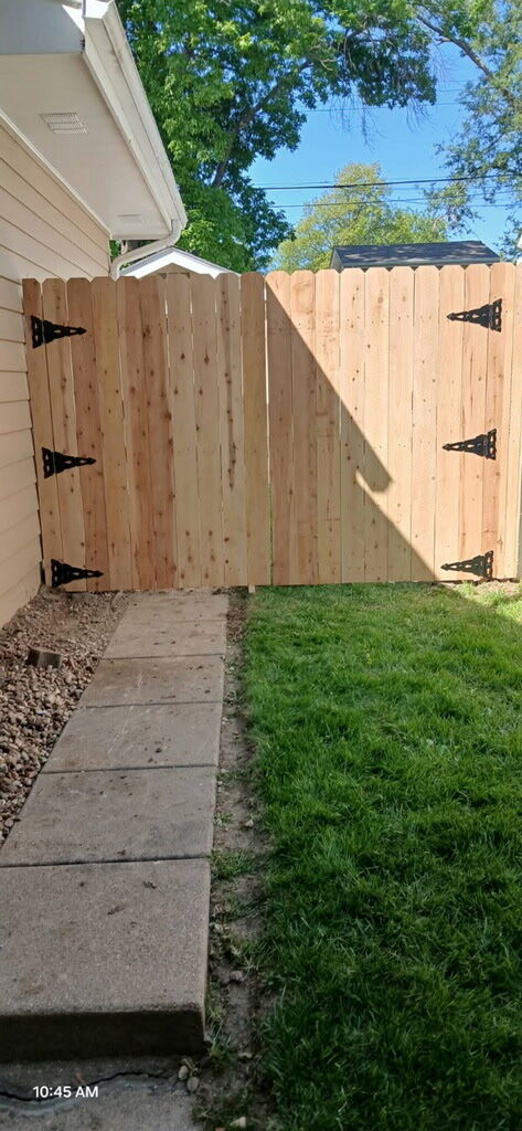New cedar fence and gate beside a stone path in Omaha