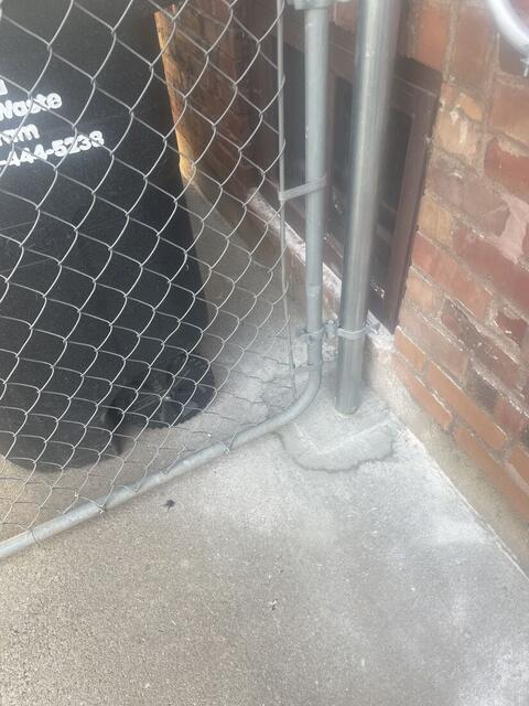 New gate post set into cleanly cut and caulked concrete