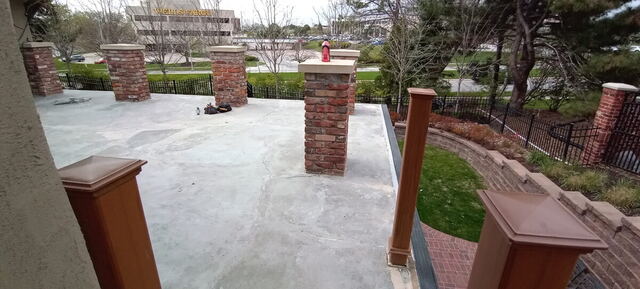 Resurfaced concrete patio with brick pillars in Omaha