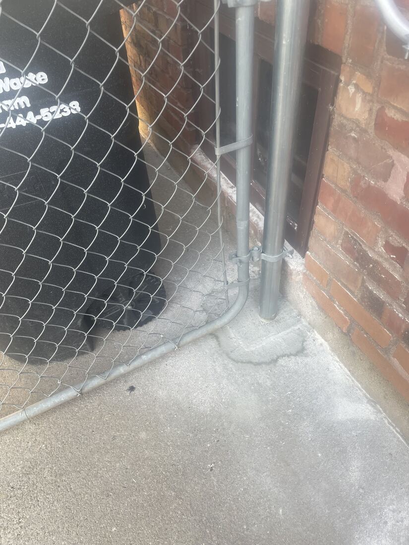 New gate post set into cleanly cut and caulked concrete